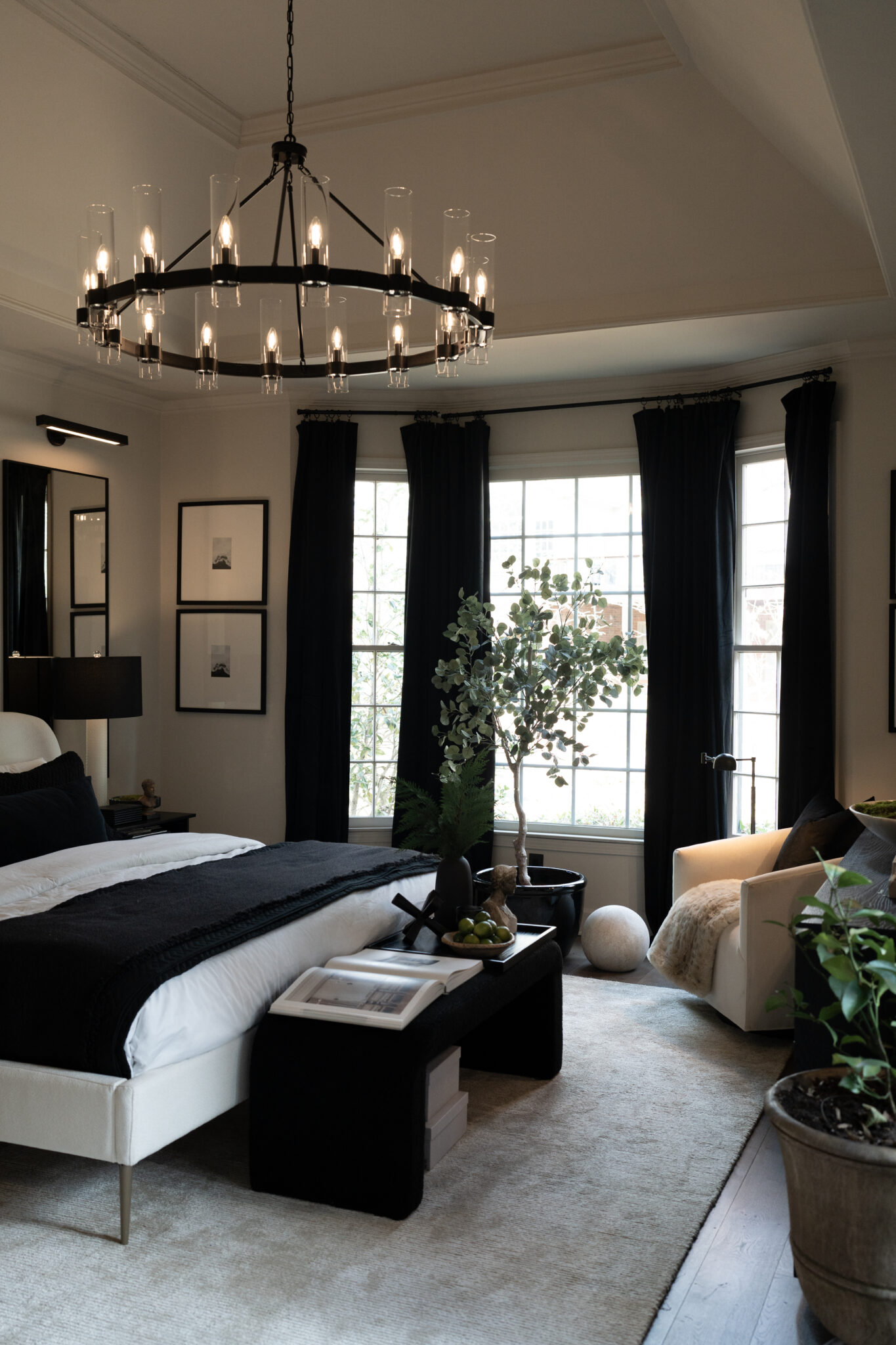 Bedroom with layered warm lighting from a bedside lamp and sconces